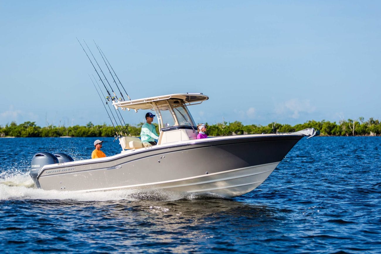 Three people going offshore for a fishing trip on a Grady-White Fisherman 257 during a beautiful sunny day.